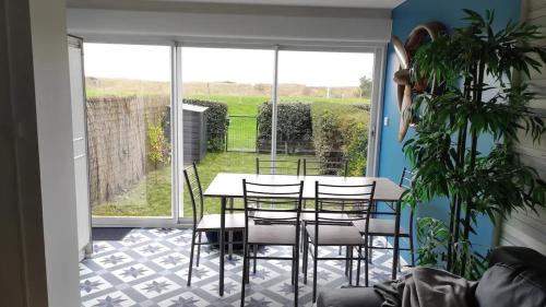 a dining room with a table and chairs and a window at Appartement cosy à Damgan avec vue mer 32 m² in Damgan