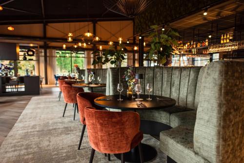 RheezeKampeerdorp de Zandstuve - Kindvriendelijke Vakantiepark的一间有桌椅的餐厅