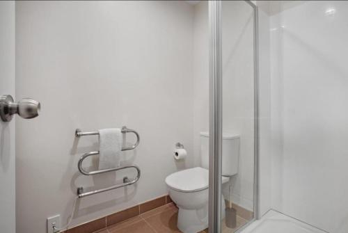 e bagno con servizi igienici e cabina doccia in vetro. di Skytower View With Swimming Pool and Gym ad Auckland