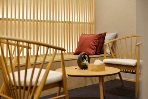 a cat sitting on a table in a room with chairs at NEW Hotel Komugi Skytree - modern Japanese-style guesthouse near Asakusa & Skytree 3mins, whole house rental perfect for large groups up to 14pax in Tokyo
