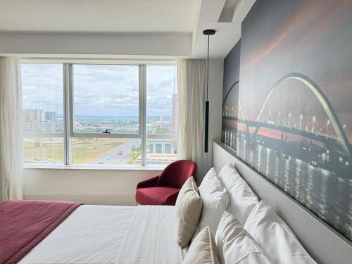 a hotel room with a bed and a red chair at Fabuloso Hotel Alvorada - Apt da Rede Premium in Brasilia