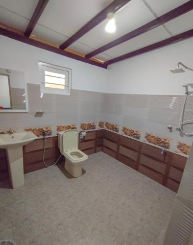 a bathroom with a toilet and a sink and a shower at White House Mirissa in Mirissa