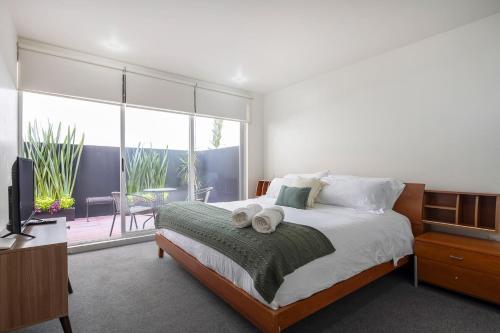una camera da letto con un letto, una televisione e un balcone di Chic 2BR Condo in Condesa steps from Parque Mexico a Città del Messico
