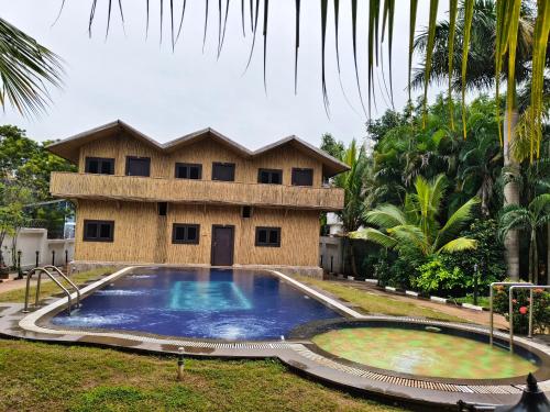 una casa con una gran piscina frente a ella en The Exotic Aura Resort, en Pondicherry