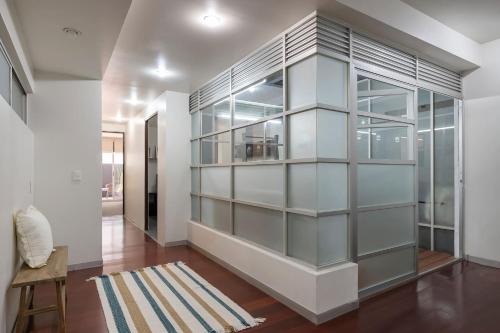 una camera con una grande parete di vetro di Chic 2BR Condo in Condesa steps from Parque Mexico a Città del Messico