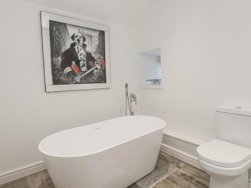 a white bathroom with a tub and a toilet at Ty'n Lon Farm in Pwllheli