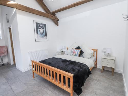a bedroom with a bed and a wooden bench at Ty'n Lon Farm in Pwllheli