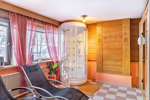 a bathroom with a shower and a chair in a room at Landhaus Perktold in Nesselwängle