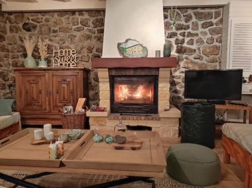 uma sala de estar com uma lareira e uma mesa em Julie's House em Chanéac