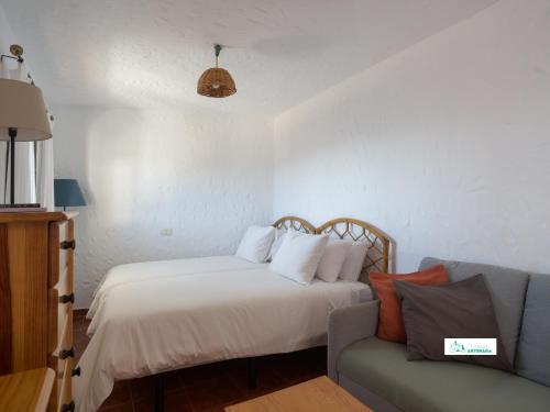 a bedroom with a bed and a couch at Living Artenara - EARTH Adults Only in Artenara