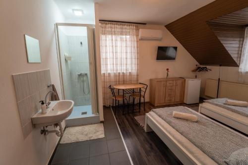 Un baño con dos camas y un lavabo y un lavabo. en Sárga Csikó vendégház, en Debrecen