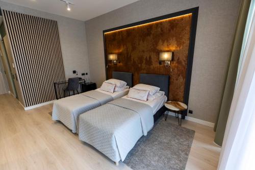 SochocinHotel Bonifacio SPA&SPORT Resort的酒店房间里有两张床，铺着白色床单