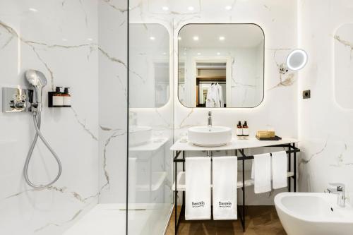een witte badkamer met een wastafel en een spiegel bij Barceló Roma in Rome