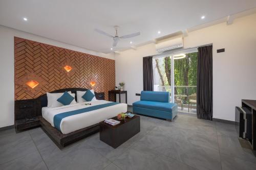 una camera da letto con un letto grande e una sedia blu di Echor Kia - A Boutique Hotel Anjuna Goa ad Anjuna