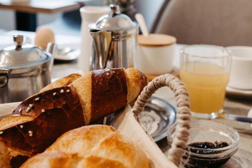 a basket of bread on a table with a glass of orange juice at Pension Adler in Sonthofen