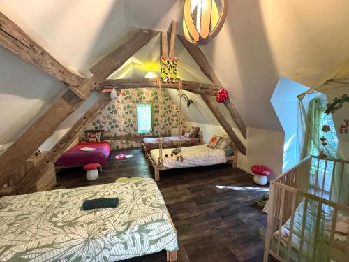 Una habitación abuhardillada con una cama y una escalera en La Maison Labonnechose - Piscine chauffée - Calme - Jeux, en Notre-Dame-de-Fresnay