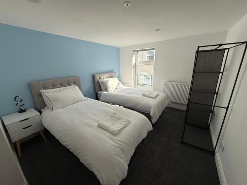 ein Schlafzimmer mit zwei Betten und einem Fenster in der Unterkunft The Chepstow Hive in Chepstow