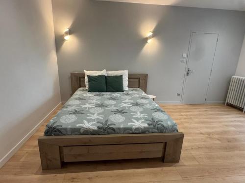 a bedroom with a bed with a green pillow at Au plaisir de l'ivoie in Le May-sur-Èvre