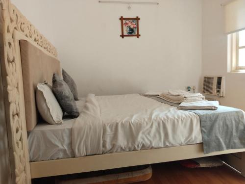 a bed with white sheets and pillows in a bedroom at 1Bhk URA Apartment Candolim in Candolim