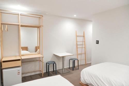 a bedroom with a bed and a desk and two stools at Morf Stay in Seoul