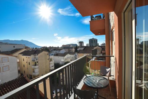 uma varanda com uma mesa e vista para a cidade em Apartmani Resna Budva em Budva