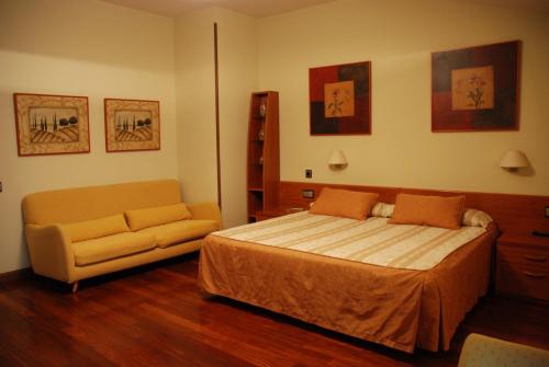 a bedroom with a bed and a couch at Hostal Los 5 Pinos in Madrid