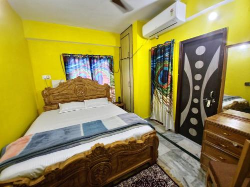 a bedroom with a large bed and yellow walls at mahitra beautiful homestay in Patna