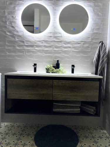 a bathroom with a white sink and two mirrors at Morava apartmán 6 manželská postel a postel pro 3 osobu, parkování zdarma-Uherské Hradiště Šafaříkova 855 in Uherské Hradiště