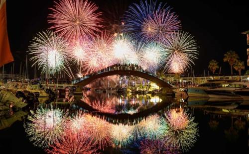 a bridge with fireworks over a body of water with boats at Magnifique appartement à 300m des plages à Port Frejus in Fréjus