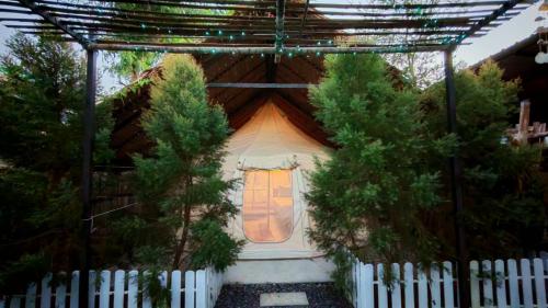a small house with a white fence and trees at Bambus Restaurant, Bar & Glamping in Patong Beach