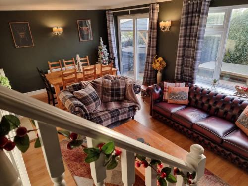 a living room with a couch and a table at Spacious 4 Bed Holiday Home with Hot Tub & Parking near Matlock Peak District in Crich