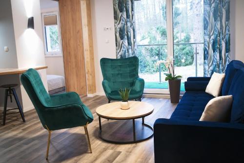 Una sala de estar con un sofá y sillas y una mesa. en Apartamenty Dąbrówka Cieplice Zdrój, en Jelenia Góra