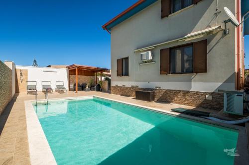 ein Swimmingpool vor einem Haus in der Unterkunft Villa DellOmbra in Alcamo