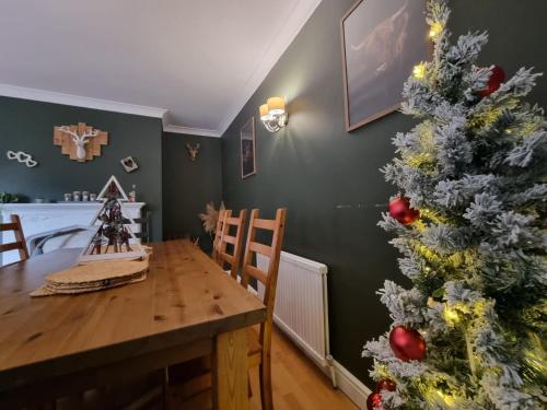 una sala da pranzo con albero di Natale e tavolo in legno di Stag House with Hot Tub, Games Room & Parking in Matlock near the Peak District a Crich