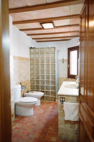a bathroom with two toilets and a sink and a mirror at Casa Rural Álvarez in Caravaca de la Cruz