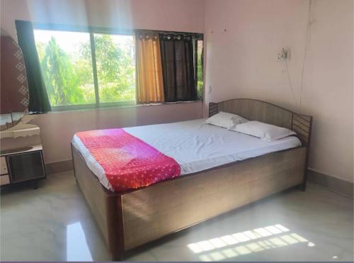 a bedroom with a bed in a room with a window at Shobuj Kutir সবুজ কুটির in Ghātsīla