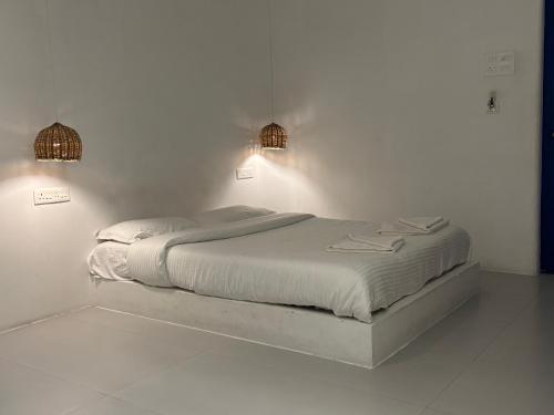 蓬蒂切里The Balified Villa的白色客房的一张床位,配有两盏灯