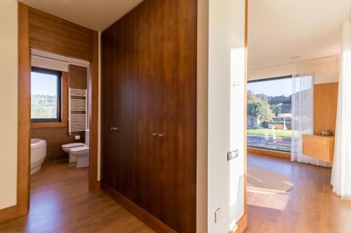 a bathroom with a wooden door and a toilet at Villa Monasterio in Escobedo