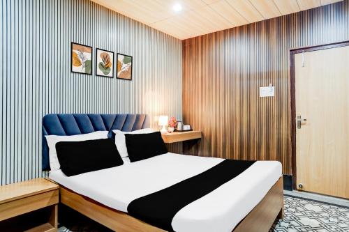 ein Schlafzimmer mit einem großen Bett mit blauem Kopfteil in der Unterkunft Hotel O Nepali Mandir Bus Terminal Formerly Hotel Aaghnya in Guwahati