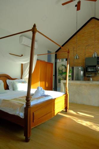 ein Schlafzimmer mit einem Bett mit Holzbettgestell in der Unterkunft Fieldlight pool Villa in Mae Rim