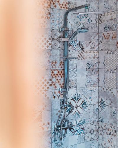 a shower in a bathroom with a tile wall at Igiwano guest house in Essaouira