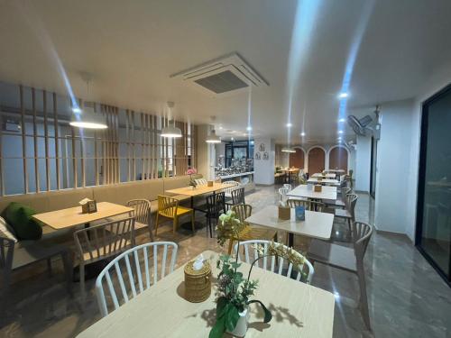 a restaurant with tables and chairs in a room at Bangkok Boutique Resort Rangsit in Pathum Thani