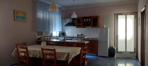 una cocina con una mesa y un refrigerador en Apartman Alenka, en Tkon