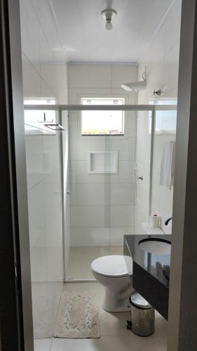 a bathroom with a shower and a toilet and a sink at Hotel Guarany in Canoinhas