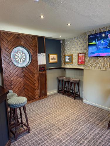 a bar with stools and a tv in a room at The Rampant Horse Public House in Fakenham
