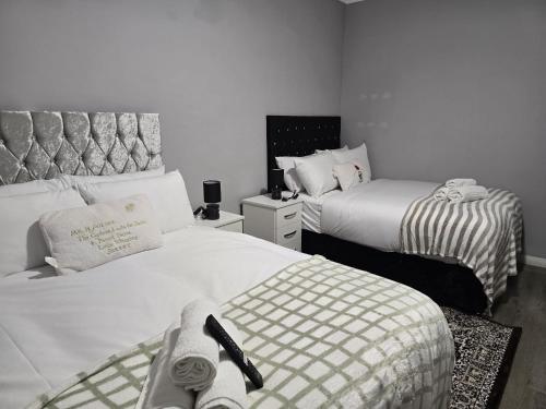 two beds in a small room with two beds sidx sidx sidx at Heathrow roomzzzz BnB in Hayes