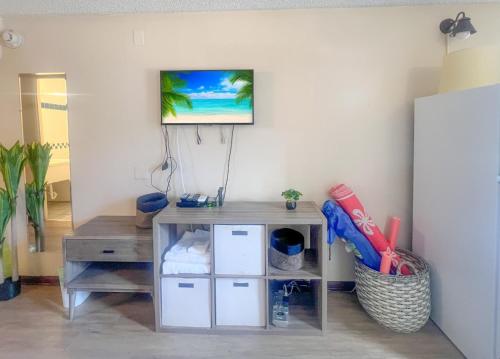 un soggiorno con una TV a parete di Happy Hawaiian Monarch Studio condo a Honolulu