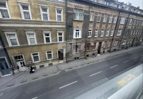 a person is sitting on the side of a city street at Modern & Cozy apartment in center -Walk everywhere in Sarajevo