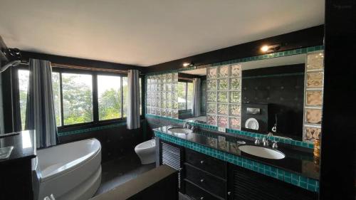 ein Badezimmer mit zwei Waschbecken, einer Badewanne und einer Badewanne in der Unterkunft Little Hill in Haad Rin