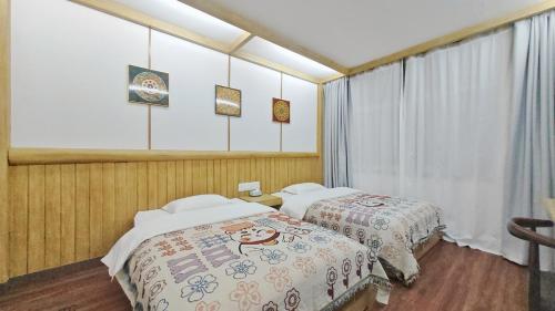 ein Schlafzimmer mit zwei Betten und einem Fenster in der Unterkunft Breeze Alley Inn--English reception and Tourism planing and Ticket reservation -Zhangjiajie in Zhangjiajie